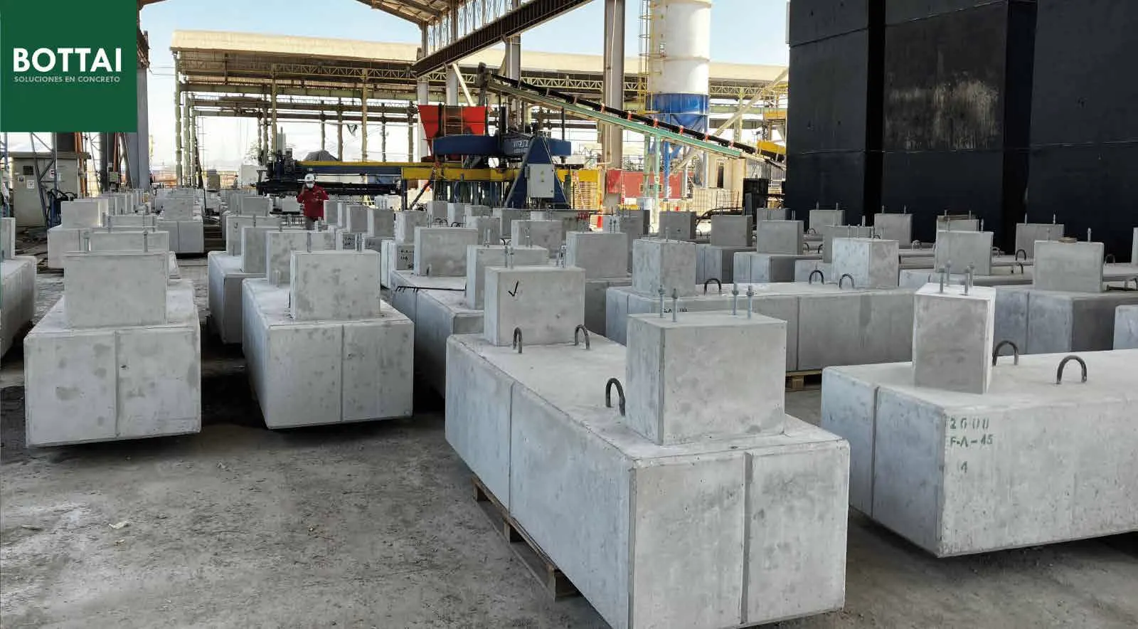 Patio de una planta Bottai con bloques de hormigón recién desmoldados bajo la nave de producción