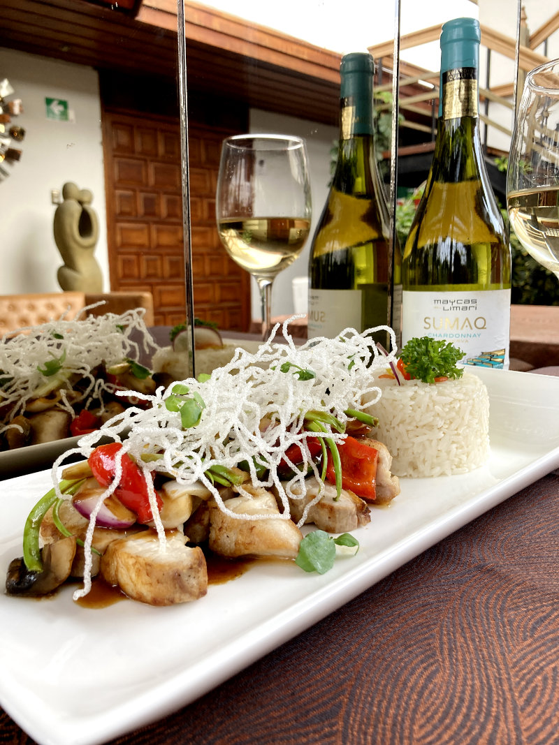 Plato de fusión italo-peruana de Rayú con copa de vino blanco